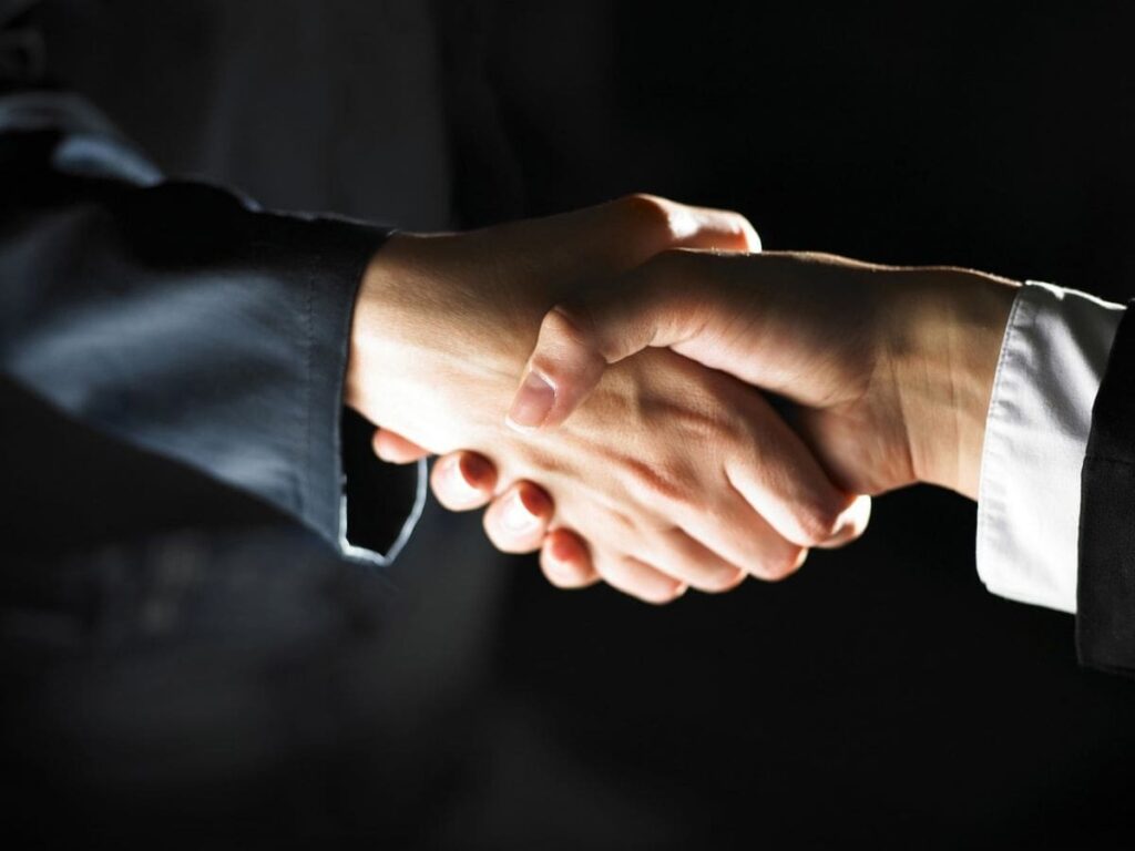 Individuals in professional attire shaking hands.